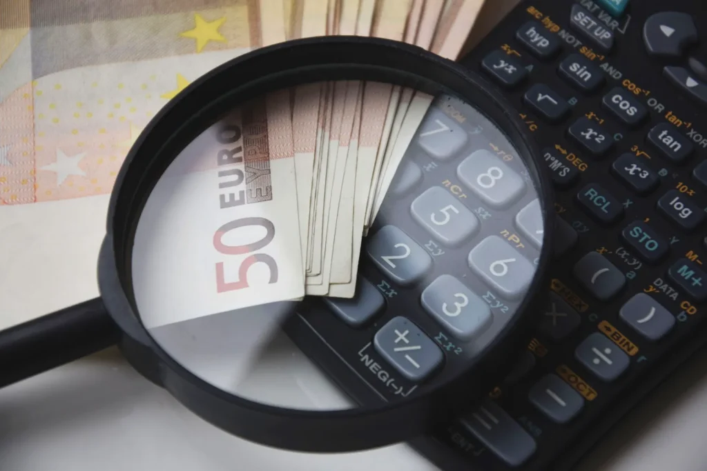 Magnifying glass zooming in on Euro banknotes and a scientific calculator